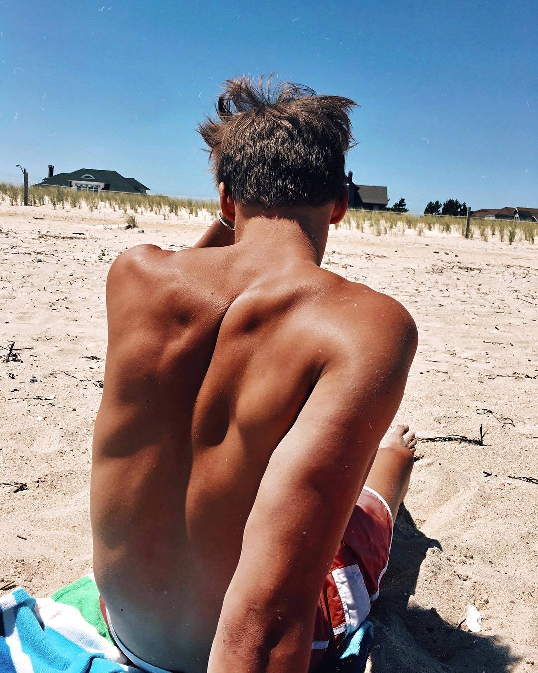 Мужчина на пляже со спины